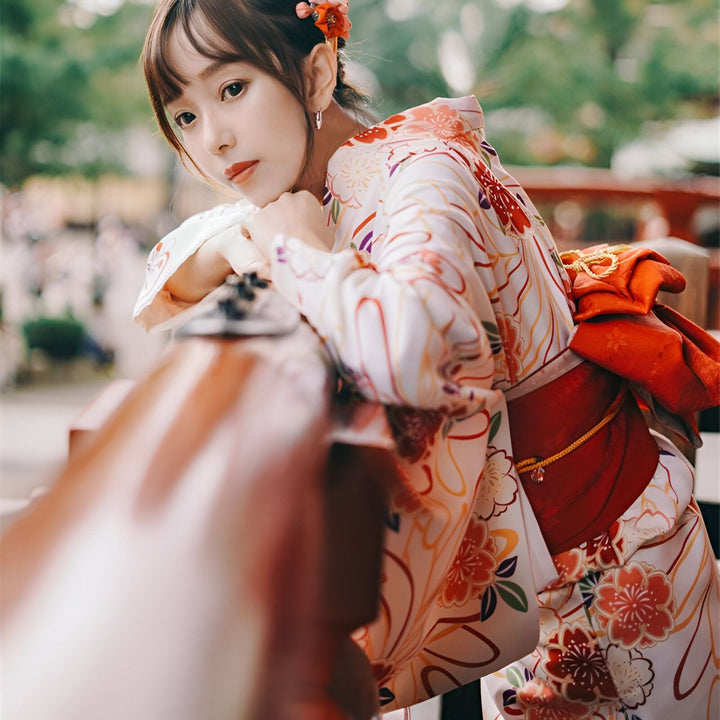 Femme en kimono traditionnel japonais à motifs floraux. Découvrez notre collection de kimonos authentiques.