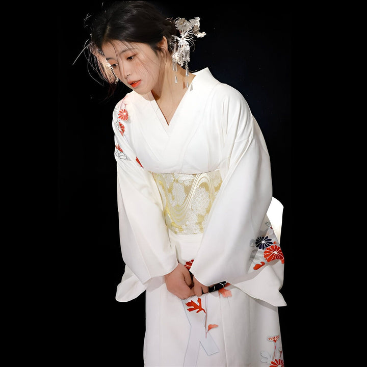 Femme portant un kimono blanc traditionnel avec motifs floraux et ceinture obi dorée. Bijou de cheveux argenté. Kimonos en vente.