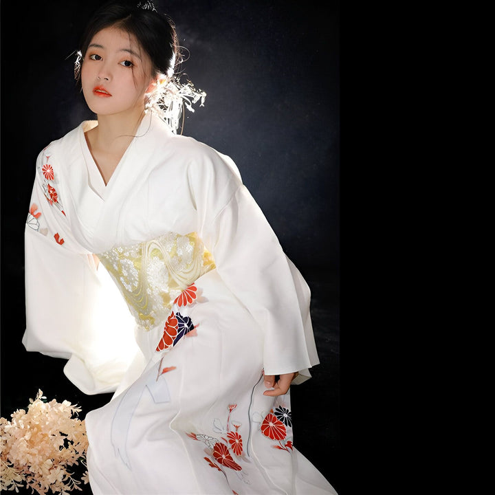 Jeune femme portant un kimono blanc traditionnel avec des motifs floraux rouges et un obi doré. Kimono japonais authentique à vendre.