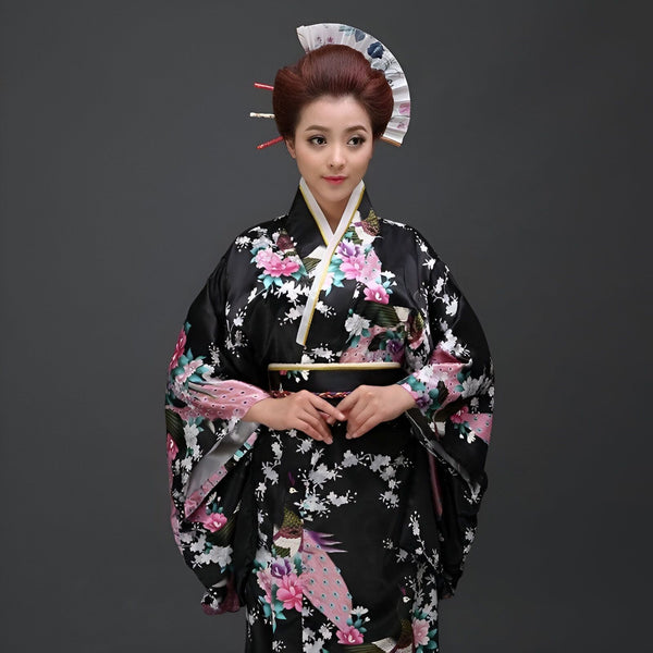 Femme portant un kimono noir à fleurs et un ornement de cheveux traditionnel. Kimonos authentiques en vente.