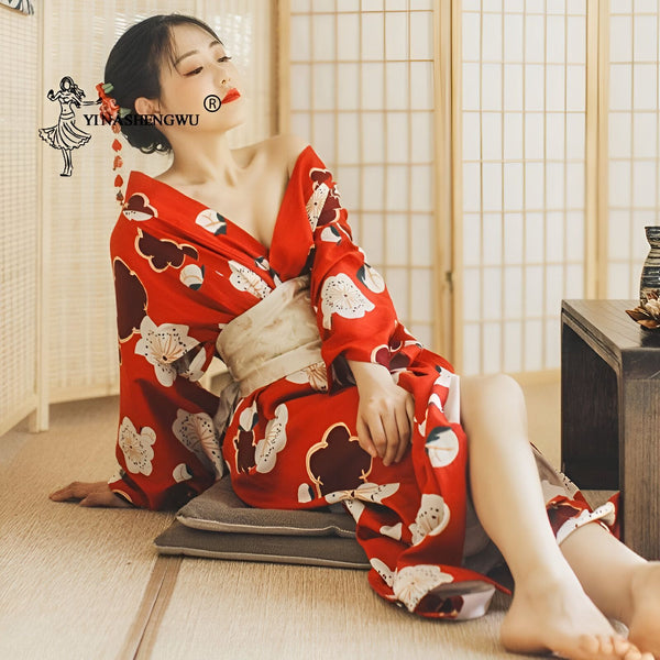 Femme assise portant un kimono rouge fleuri traditionnel avec une ceinture obi. Kimonos de haute qualité disponibles à l'achat.