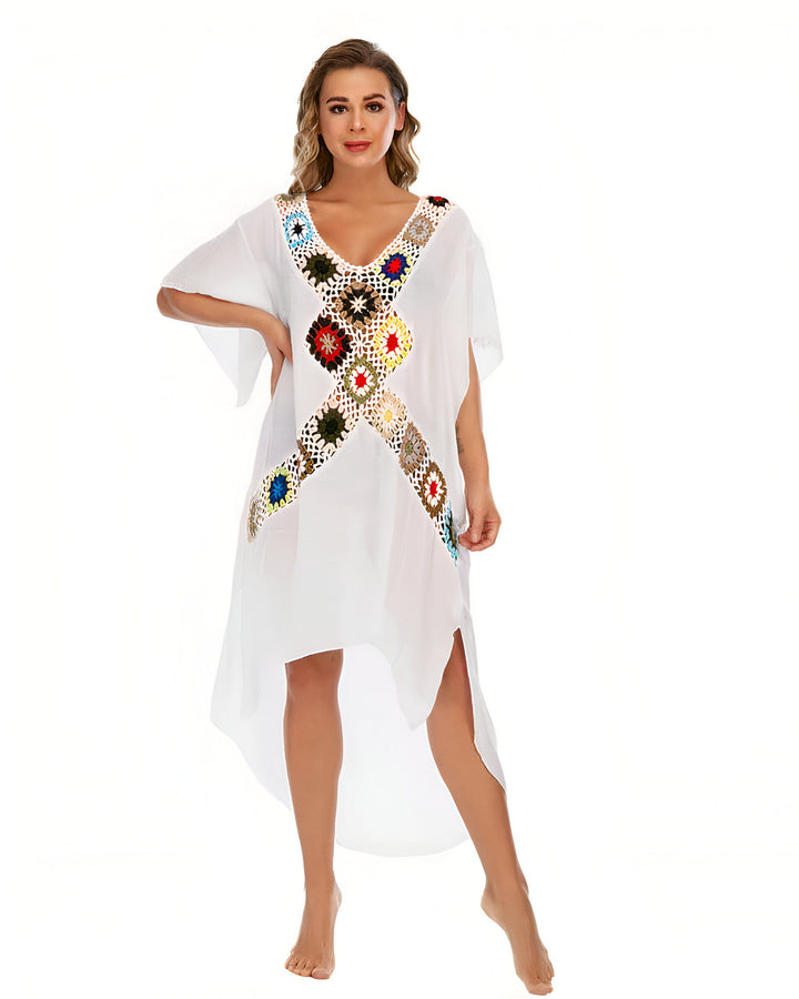 Femme portant un kimono blanc avec motifs colorés au crochet. Kimono d'été parfait pour la plage. Découvrez notre collection de kimonos uniques.