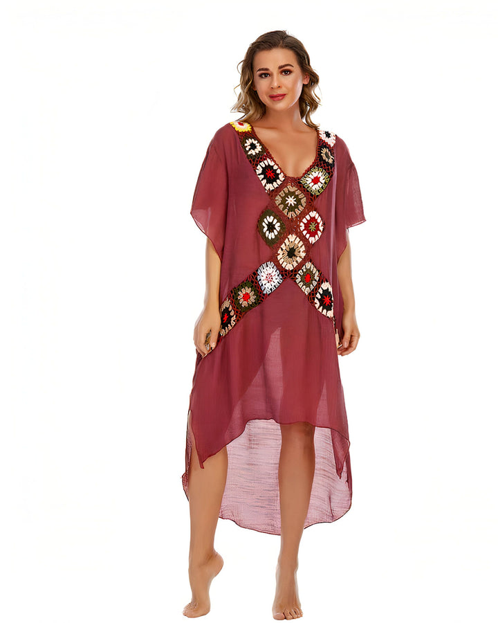 Femme portant un kimono rouge avec des motifs floraux en crochet colorés. Vêtement ample et léger, idéal pour la plage ou comme vêtement d'intérieur élégant. Découvrez notre collection de kimonos uniques.