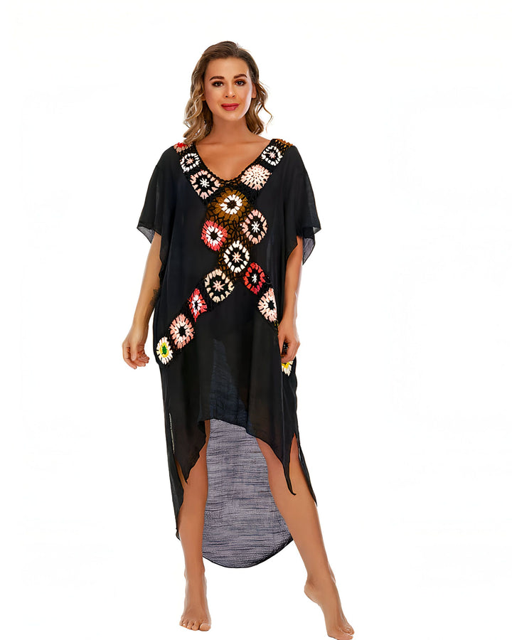 Femme portant un kimono noir avec des motifs floraux colorés. Idéal pour la plage ou la détente à la maison. Découvrez notre collection de kimonos uniques.