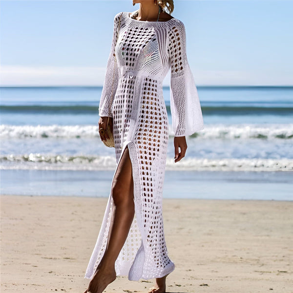 Femme portant un kimono de plage blanc ajouré avec une fente sur le côté, sur une plage ensoleillée. Idéal comme vêtement de plage chic. Découvrez notre collection de kimonos.
