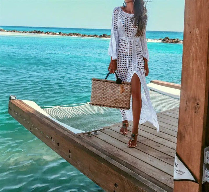 Femme portant un kimono blanc en crochet sur une jetée tropicale. Kimonos de plage élégants disponibles à l'achat.