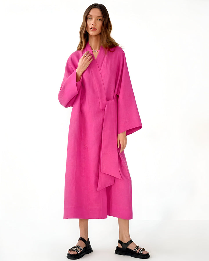 Femme portant un kimono rose vif, noué à la taille. Kimono long et ample, manches larges. Style décontracté et élégant. Collection de kimonos.