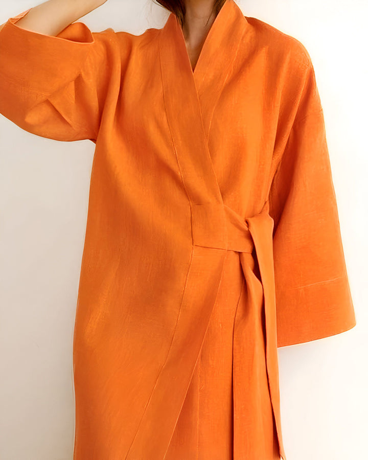 Femme portant un kimono orange, noué à la taille. Vêtement japonais traditionnel, disponible à l'achat.