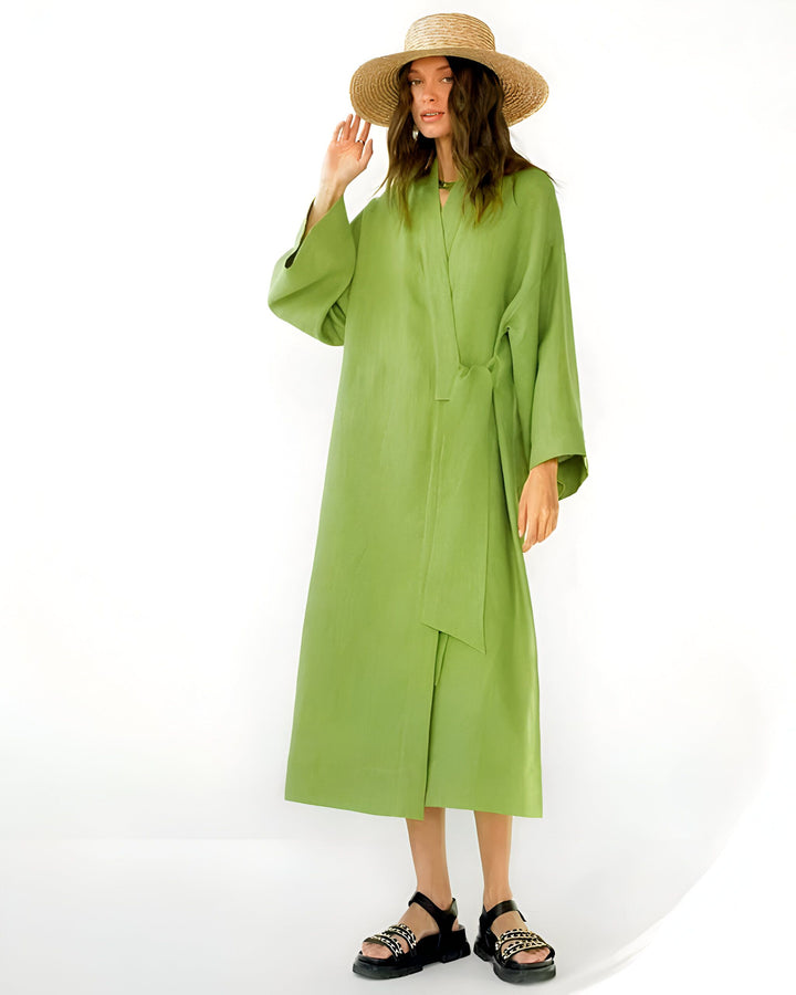 Femme portant un kimono vert avec un chapeau de paille. Kimono élégant et confortable disponible à l'achat. Vêtements de détente tendance.