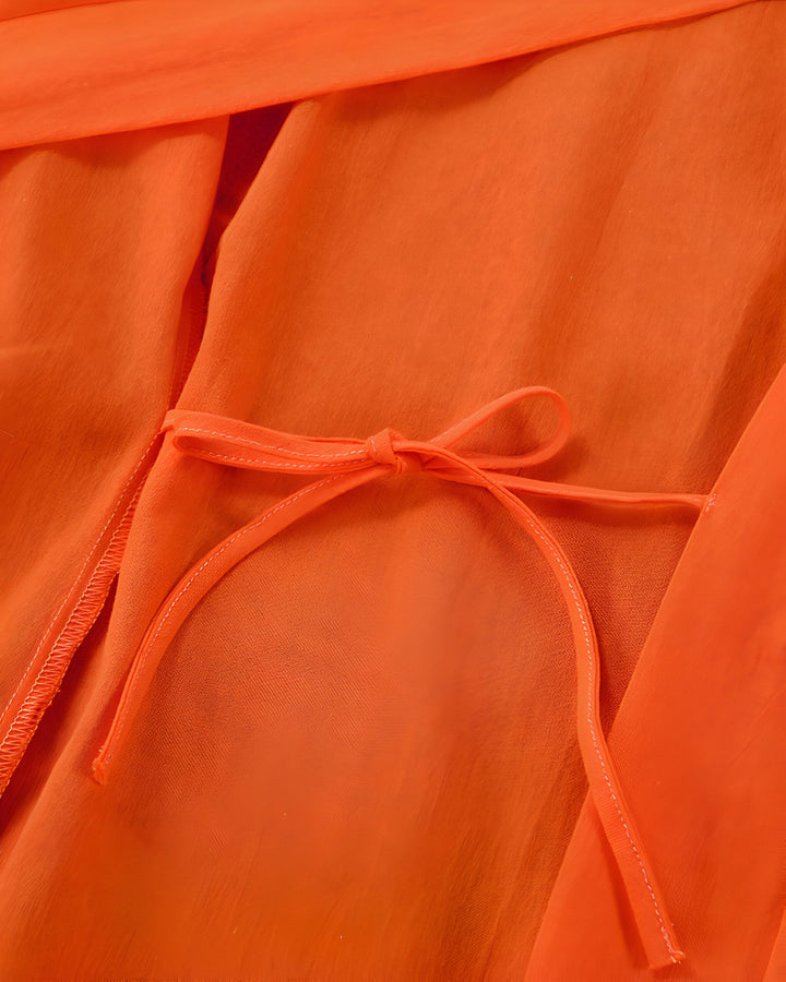 Détail d'un kimono orange avec une ceinture à nouer. Gros plan sur la texture du tissu et le nœud de la ceinture. Kimonos de haute qualité à vendre.