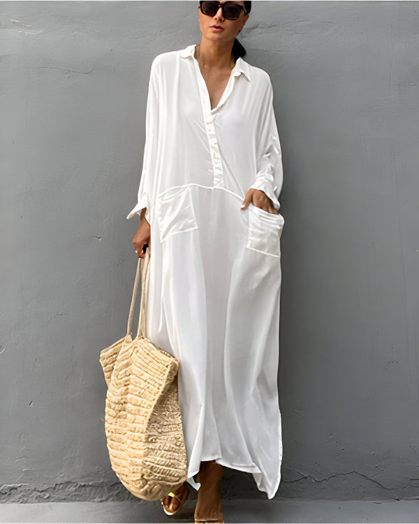 Femme portant une robe kimono blanche longue avec des lunettes de soleil, un sac en raphia et des sandales dorées. Élégance décontractée. Kimonos tendances pour toutes les occasions.