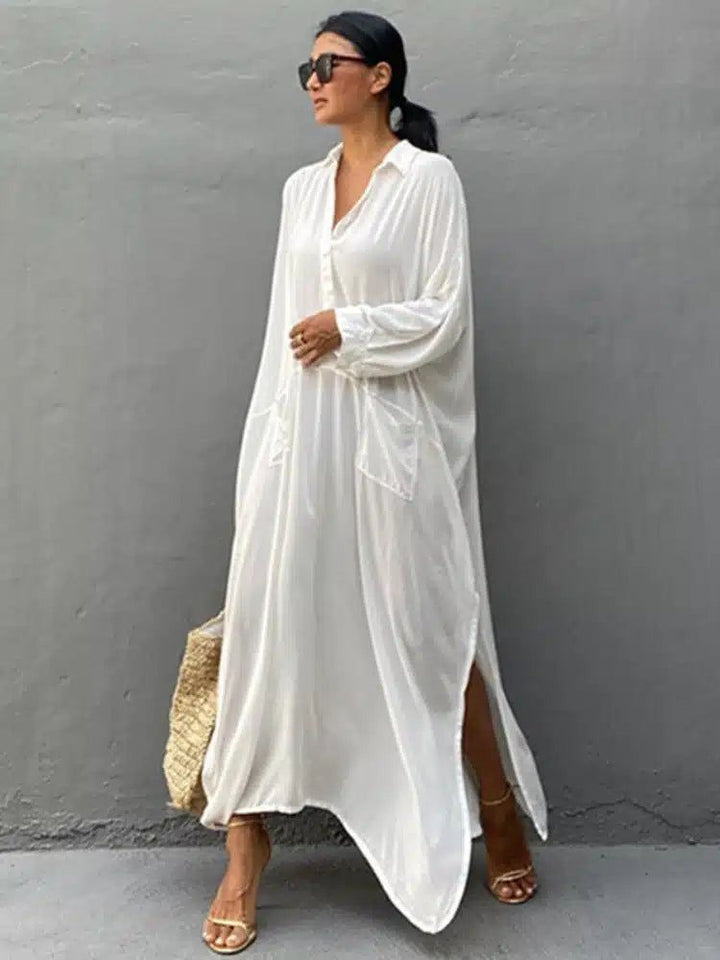 Femme portant un kimono blanc ample avec des lunettes de soleil et des sandales dorées. Achetez nos kimonos confortables et élégants.