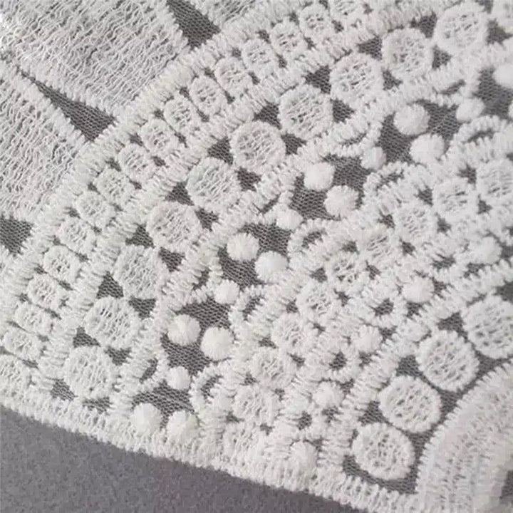 Détail de dentelle blanche sur un kimono. Texture délicate et motifs floraux pour une élégance subtile. Découvrez notre collection de kimonos uniques.
