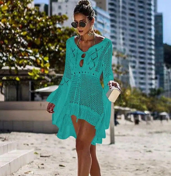 Femme portant un kimono turquoise ajouré sur la plage. Parfait comme vêtement de plage ou robe d'été. Découvrez notre collection de kimonos uniques pour un look bohème chic. Kimono à manches longues en crochet turquoise.