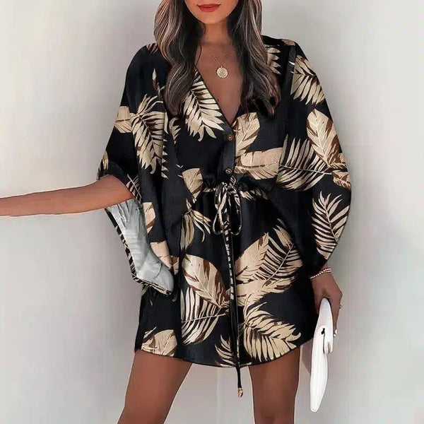 Femme portant un kimono noir à motifs de feuilles dorées. Kimono à manches courtes avec une ceinture à nouer à la taille. Vêtements de style kimono pour femmes.