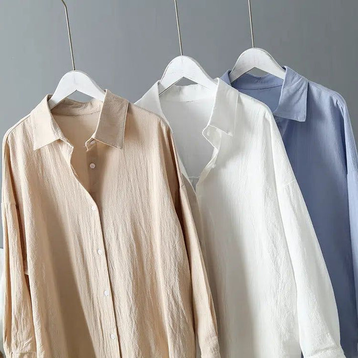 Trois chemises kimono pour femmes suspendues, beige, blanche et bleue. Collection de vêtements kimono.