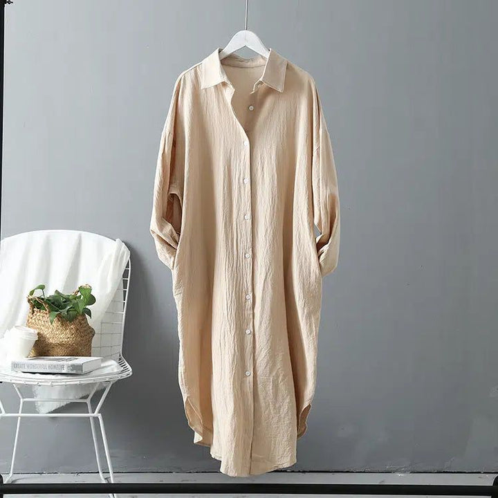 Kimono long beige suspendu sur un cintre. Chemise longue style kimono, vêtement ample et confortable. Découvrez notre collection de kimonos uniques.