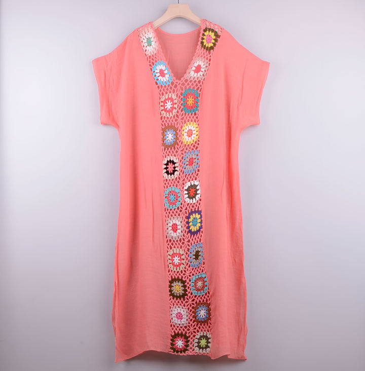 Kimono pêche avec bordure en crochet coloré, suspendu sur un cintre. Vêtement léger et estival. Notre collection de kimonos.