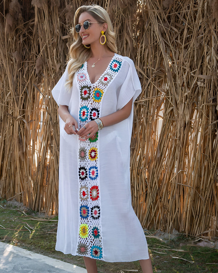Femme blonde portant un kimono blanc avec des motifs floraux colorés au crochet. Vêtements de plage, collection été.