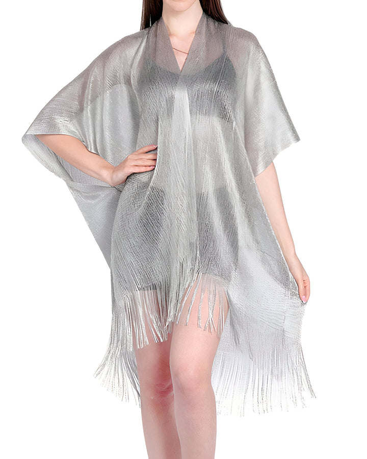 Femme portant un kimono argenté avec des franges. Élégant vêtement de plage ou d'intérieur. Collection de kimonos tendance.