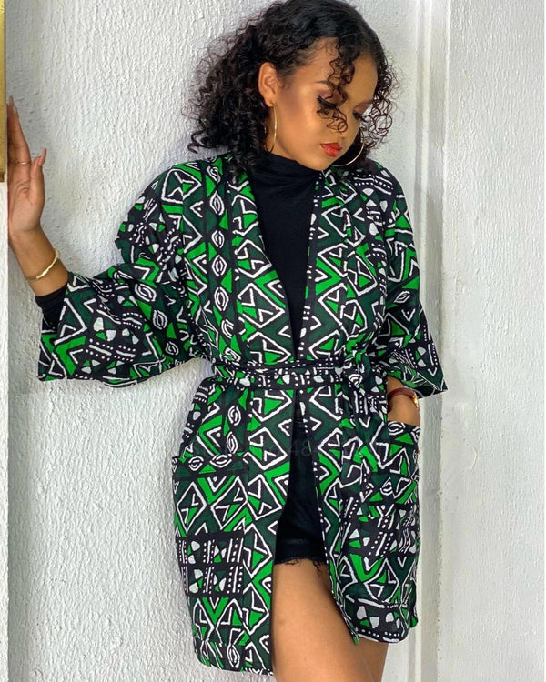 Femme portant un kimono vert et noir avec motifs. Vente de kimonos en ligne. Mode féminine, style unique, vêtements originaux. Kimono tendance pour toutes les occasions.