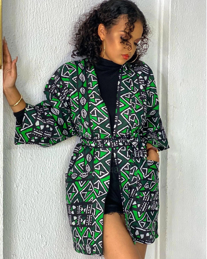 Femme portant un kimono vert et noir avec motifs. Vente de kimonos en ligne. Mode féminine, style unique, vêtements originaux. Kimono tendance pour toutes les occasions.