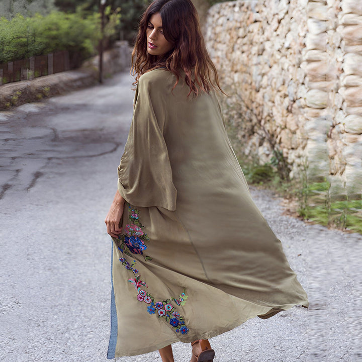 Femme portant un kimono long beige brodé de fleurs. Vêtements de style japonais.