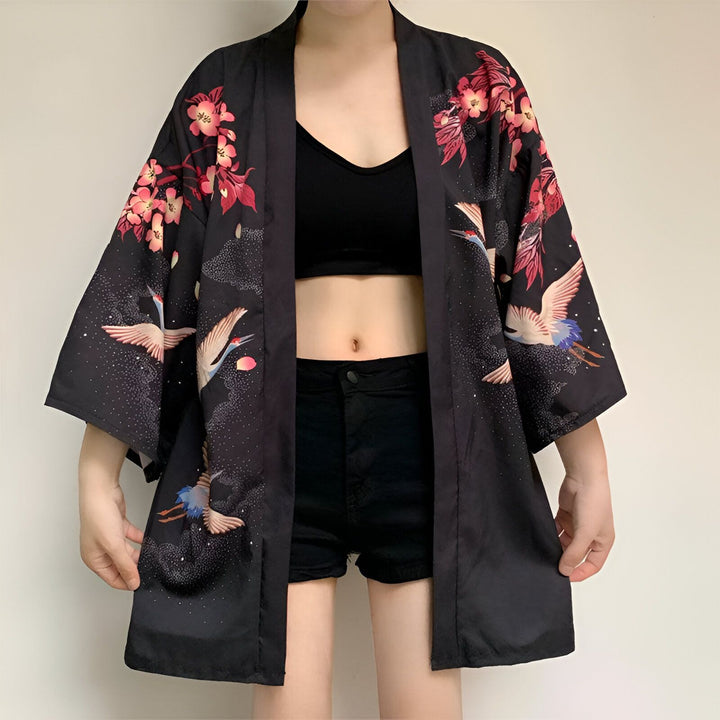 Kimono noir avec motifs de grues et de fleurs roses, faisant partie de notre collection. Vêtements de style japonais à découvrir.