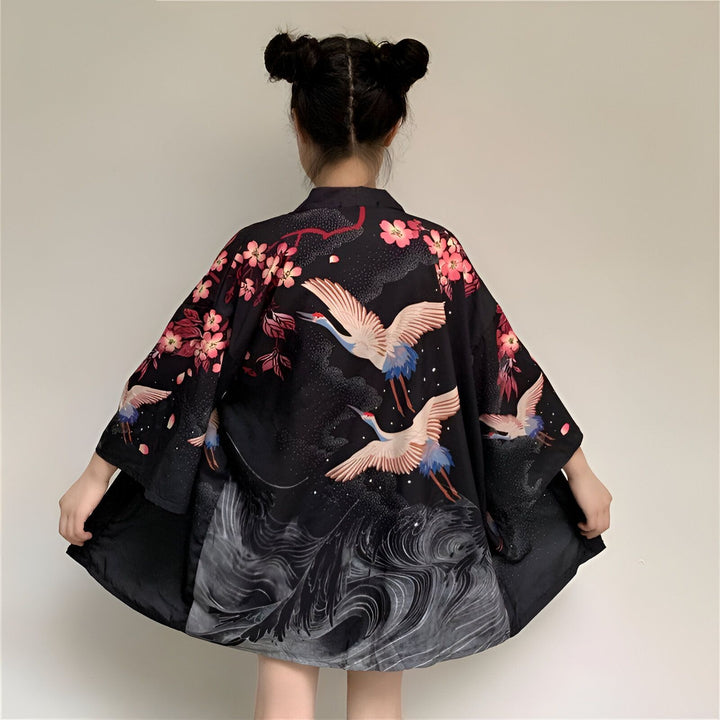 Kimono noir avec motifs de grues et fleurs roses, vue de dos. Vêtement traditionnel japonais, idéal pour un style unique et élégant. Découvrez notre collection de kimonos.