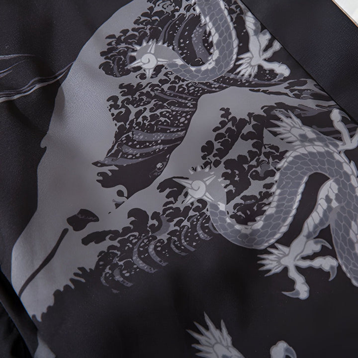 Détail d'un kimono avec motif de dragons gris et vagues japonaises sur fond noir. Vêtements japonais traditionnels.