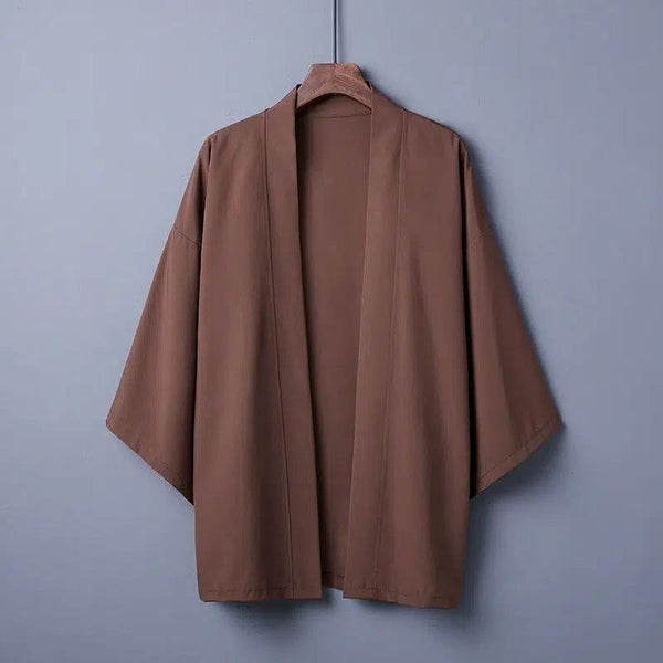 Kimono marron pour hommes suspendu à un cintre. Vêtement de style japonais avec manches larges. Découvrez notre collection de kimonos uniques.