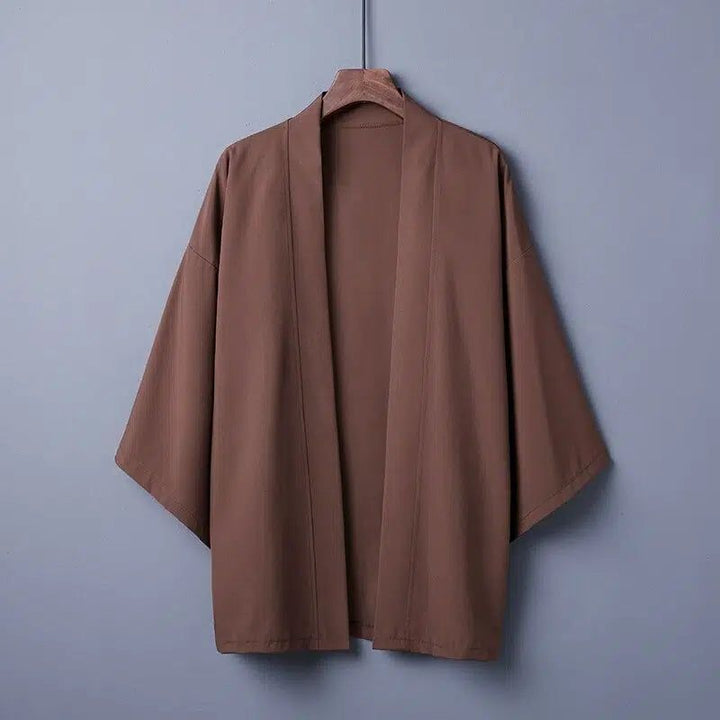 Kimono marron pour hommes suspendu à un cintre. Vêtement de style japonais avec manches larges. Découvrez notre collection de kimonos uniques.