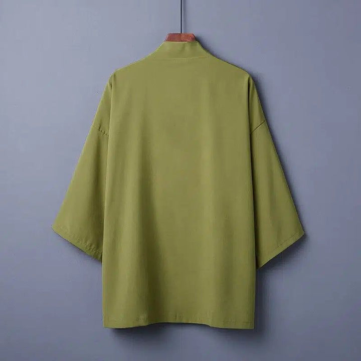 Kimono vert olive suspendu à un cintre, vue arrière. Vêtement traditionnel japonais, idéal pour un style unique et confortable. Découvrez notre collection de kimonos.