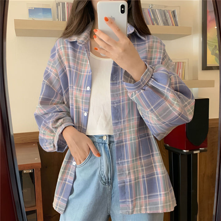 Femme portant un kimono à carreaux bleu et rose, chemise ouverte sur un débardeur blanc, jeans taille haute. Style décontracté. Notre collection de kimonos.