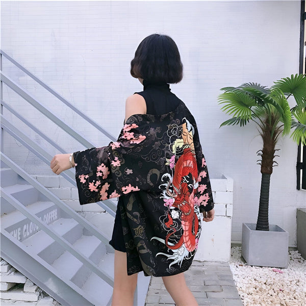 Kimono noir avec motif de dragon rouge et fleurs de cerisier roses. Vêtement de style japonais tendance et élégant. Idéal pour un look unique et sophistiqué. Découvrez notre collection de kimonos.