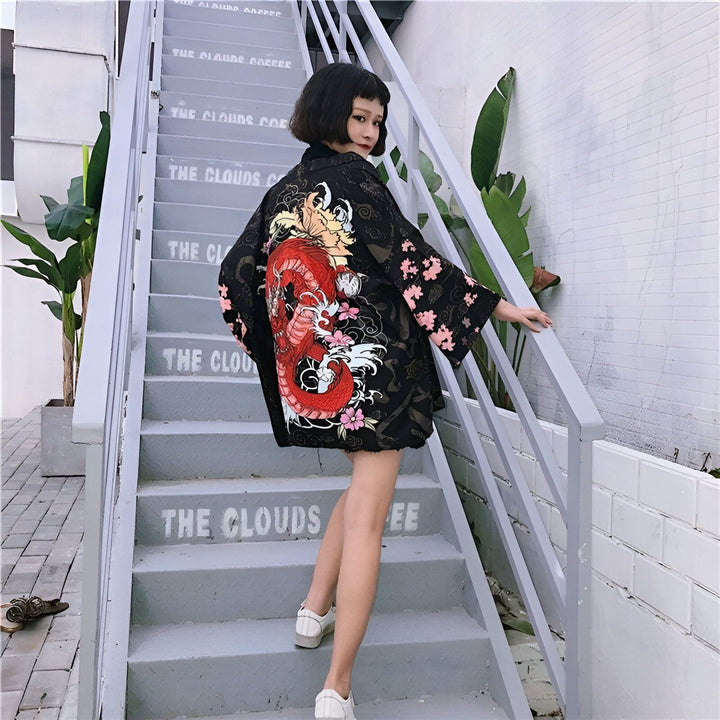 Kimono noir avec motif de dragon rouge et fleurs roses. Vêtement de style japonais parfait pour un look unique et tendance. Découvrez notre collection de kimonos originaux.
