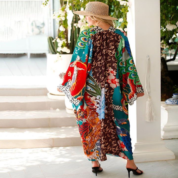 Femme portant un kimono long et coloré avec des motifs floraux et d'animaux, chapeau de paille. Vente de kimonos en ligne.