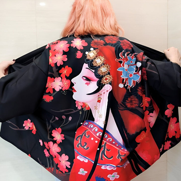 Dos d'une personne portant un kimono noir imprimé d'un portrait de geisha et de fleurs de cerisier roses. Vêtements japonais traditionnels à vendre.