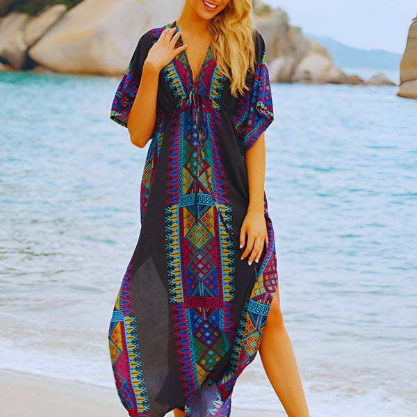 Femme souriante portant un kimono de plage noir à motifs colorés. Vêtement de plage élégant et léger, idéal pour les vacances. Découvrez notre collection de kimonos.