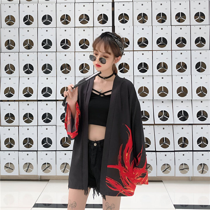 Jeune femme portant un kimono noir à motifs rouges, lunettes de soleil et bandeau. Kimonos tendance à vendre.