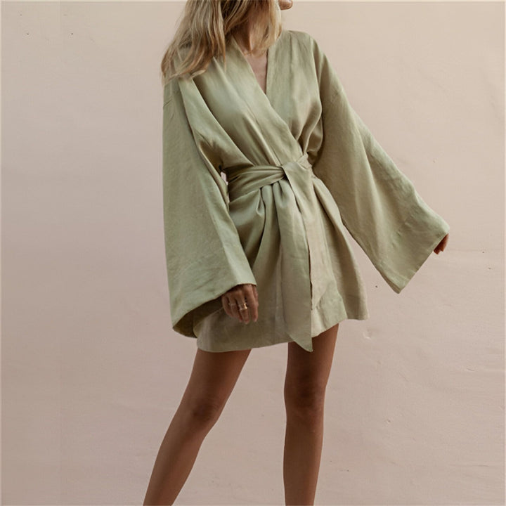 Femme portant un kimono vert clair. Kimono court en lin avec manches larges et ceinture à nouer. Vêtements de détente, robes de chambre et kimonos pour femmes.