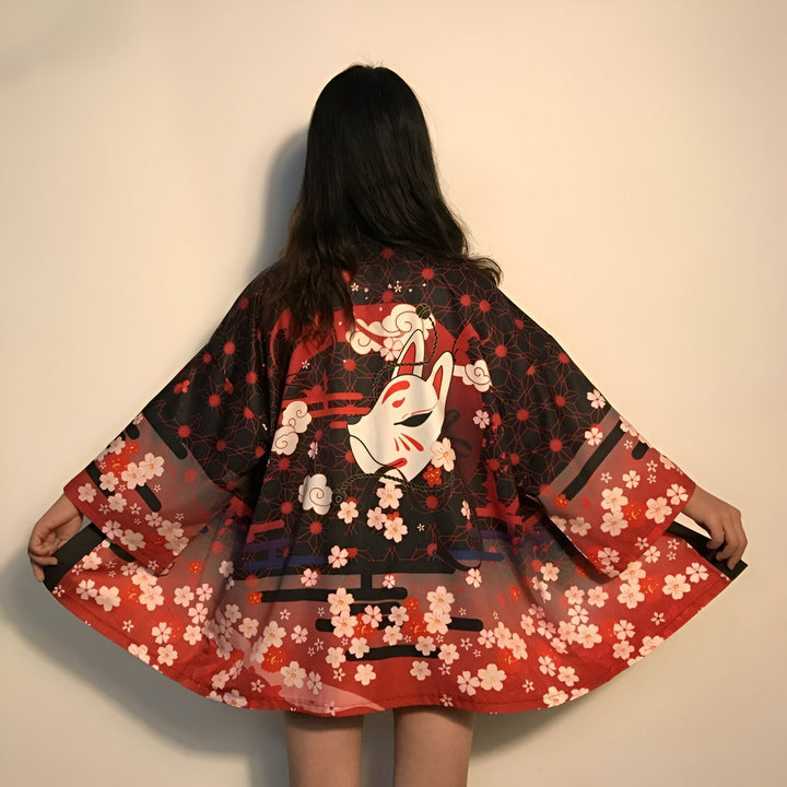 Femme portant un kimono rouge et noir avec motif de fleurs de cerisier et masque de renard. Vêtement de style japonais tendance. Kimonos à vendre.