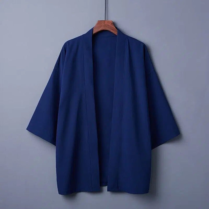Kimono bleu marine sur cintre en bois. Vêtements japonais traditionnels à manches larges. Découvrez notre collection de kimonos authentiques.