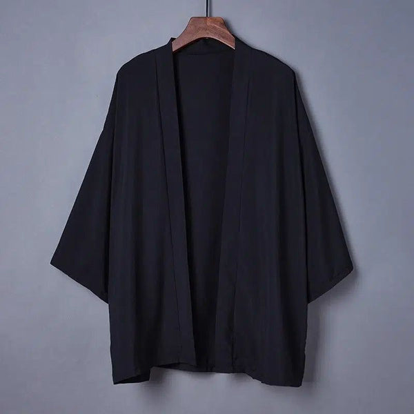 Kimono noir pour hommes, suspendu à un cintre. Découvrez notre collection de kimonos uniques.