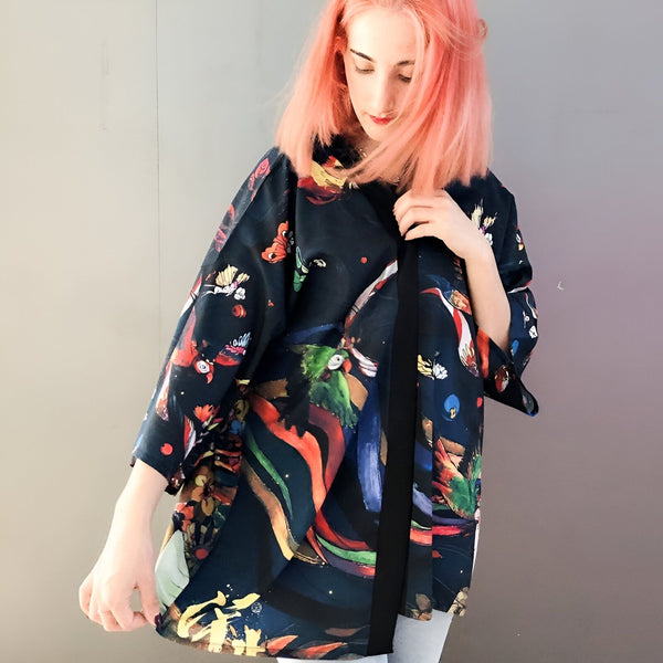 Femme aux cheveux roses portant un kimono imprimé coloré. Vêtements style japonais. Kimonos modernes et élégants en vente.