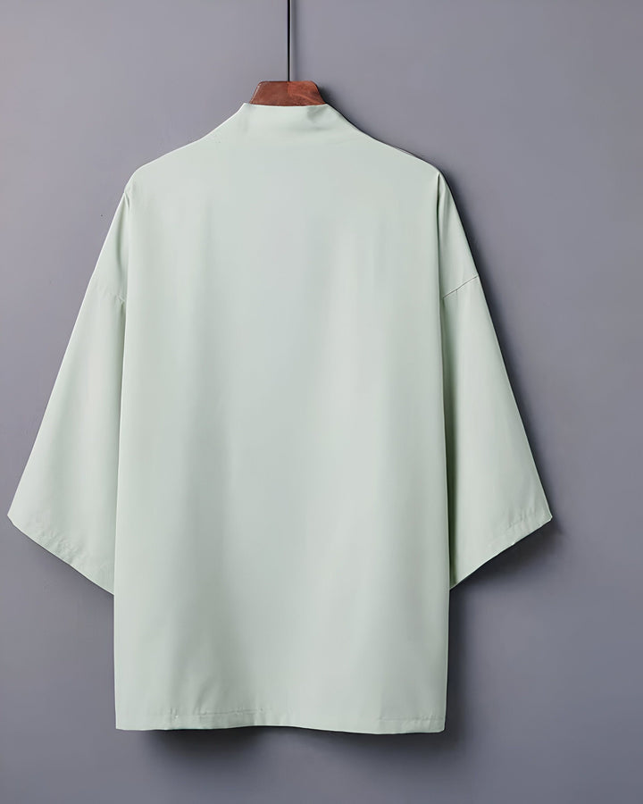 Kimono vert clair sur un cintre en bois, vue de dos. Vêtements traditionnels japonais. Boutique de kimonos en ligne.