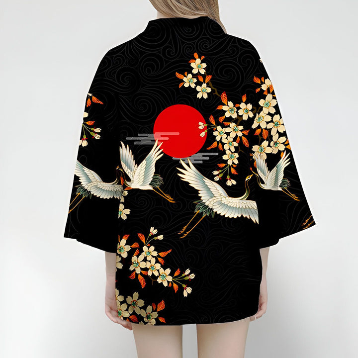 Kimono noir avec motifs japonais : grues blanches, soleil rouge, fleurs de cerisier. Vêtement traditionnel, style asiatique, mode kimono.