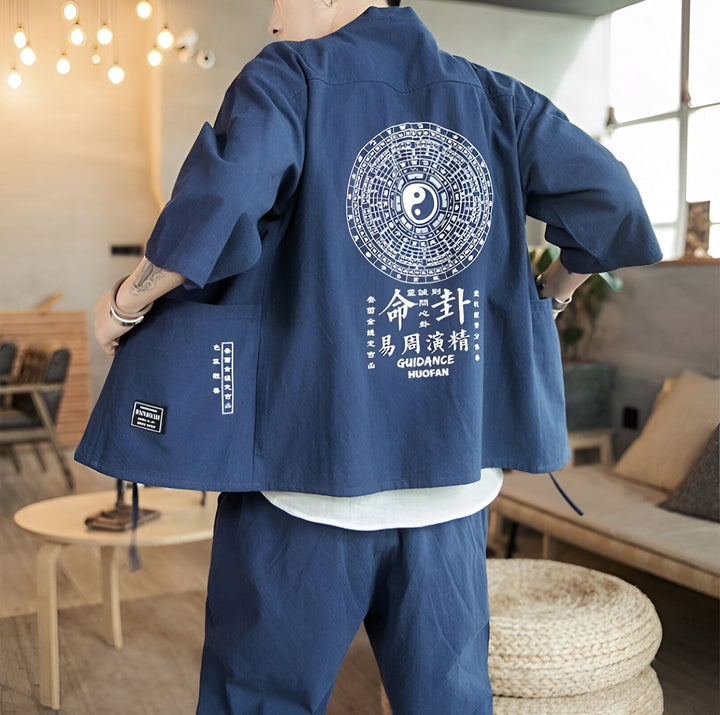Homme portant un kimono bleu avec motif Yin et Yang. Vêtements japonais traditionnels, kimono tendance. Boutique de kimonos en ligne.