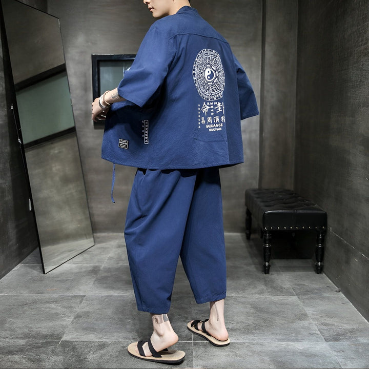 Homme portant un kimono bleu avec motif Yin Yang dans le dos et pantalon assorti. Vente de kimonos pour hommes et femmes. Style japonais traditionnel revisité.