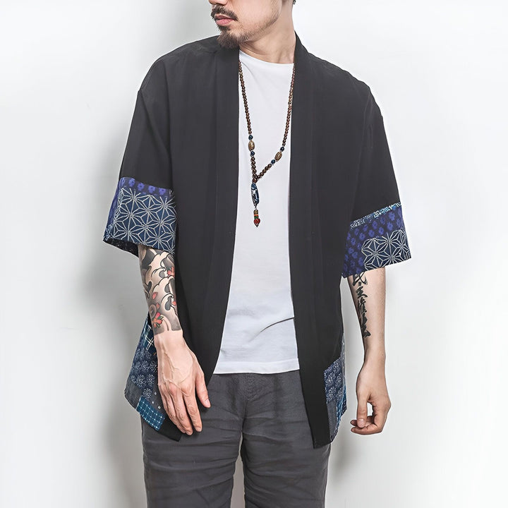 Homme portant un kimono noir avec motifs bleus sur les manches. Vêtements traditionnels japonais. Kimono pour hommes disponible à l'achat.